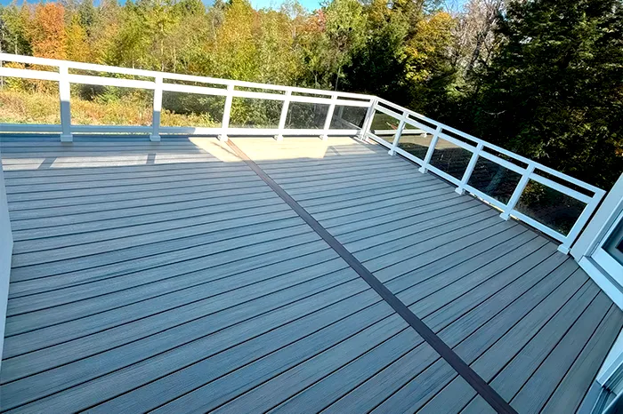 Composite deck boards and glass panel railing on a newly built upper-level deck